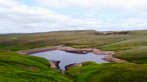 aerial view orbiting peaceful untouched marsden moorland valley lagoon in peak district countryside