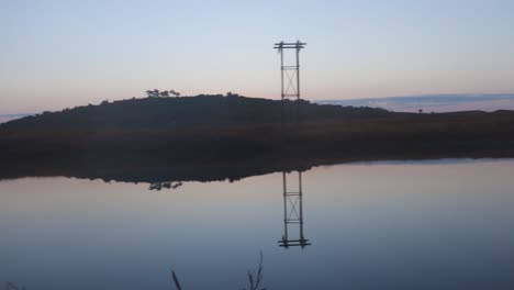 Agua-Tranquila-Del-Lago-Con-Reflejo-Y-Amanecer-Espectacular-Cielo-Naranja-Por-La-Mañana