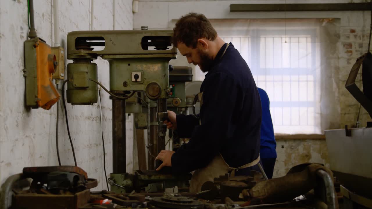 Metalsmith using drill press machine in workshop 4k