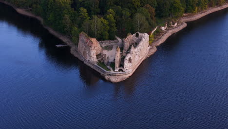 ruins of koknese castle from opposite bank of daugava river, latvia. aerial tilt up