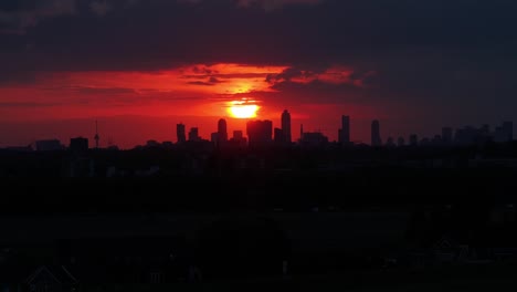 Cuando-La-Oscuridad-Comienza-A-Cubrir-Rotterdam,-La-Ciudad-Permanece-Bajo-La-Luz-Roja-De-Un-Sol-Poniente.