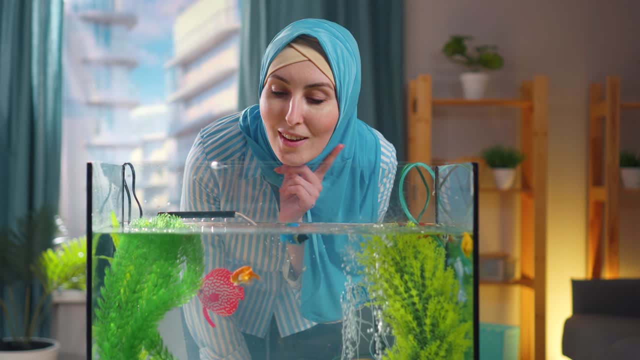 집 에 있는 금고기 수족관 을 둘러싼 무슬림 여자 의 생각