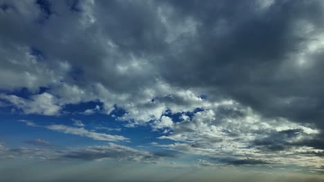 Pilot-POV-cloudscape-shot-from-an-airplane-cockpit-with-some-fluffly-clouds-in-the-sky-above-and-a-deep-blue-sky,-in-a-left-turn