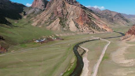 drone flying above a vast valley in kyrgyzstan, capturing breathtaking views of rolling hills, alpine meadows landscape showcases untouched nature and traditional nomadic terrain in central asia