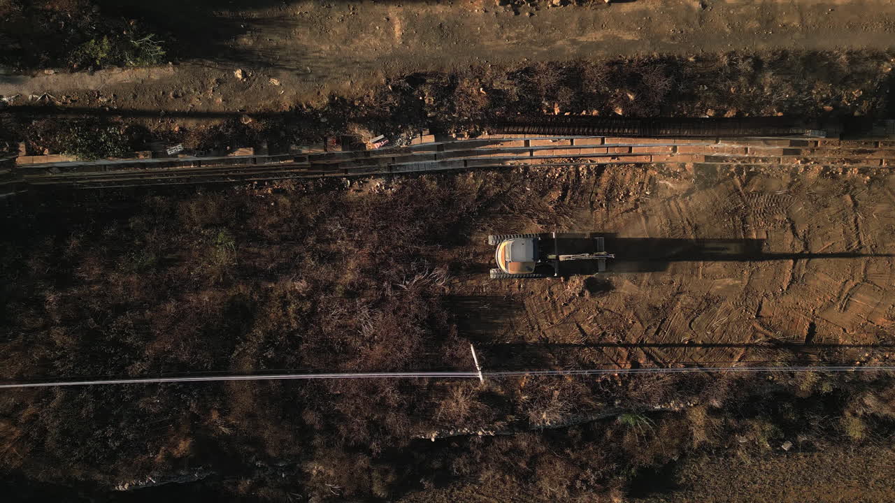vista aérea de arriba hacia abajo de una excavadora jardinería durante la puesta de sol