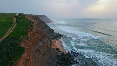 cloudy rocky sea shore aerial view. stormy ocean waves crashing coastal cliffs