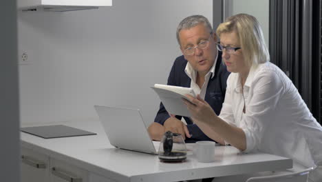 couple of adults with pad in kitchen