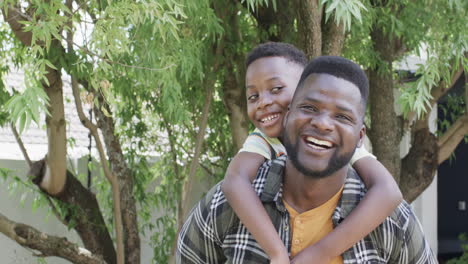 Un-Padre-Afroamericano-Con-Una-Sonrisa-Brillante-Lleva-A-Un-Hijo-Alegre-En-La-Espalda