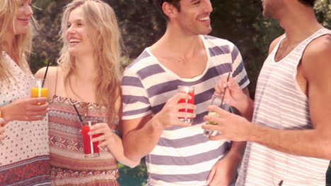 happy friends drinking by the pool