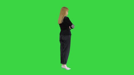 pretty blonde woman standing with arms crossed on a green screen, chroma key