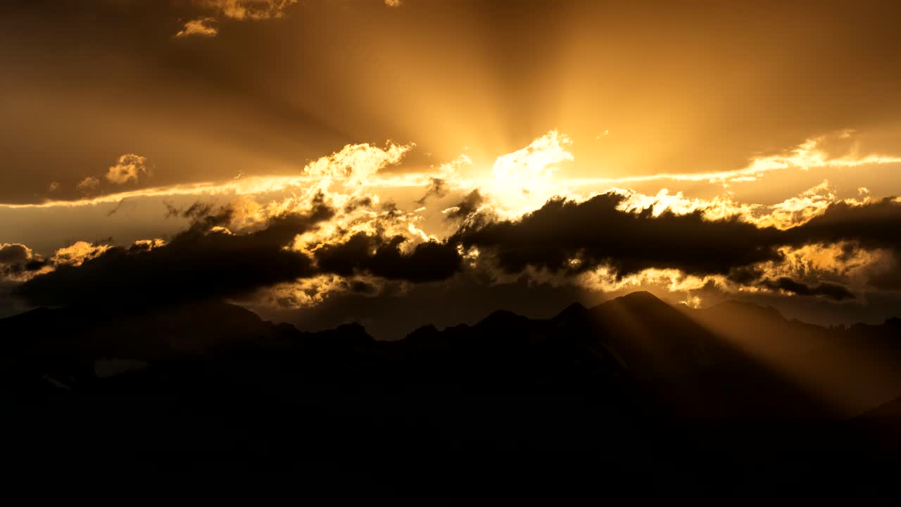lapso de tiempo de los rayos del sol sobre las montañas rocosas