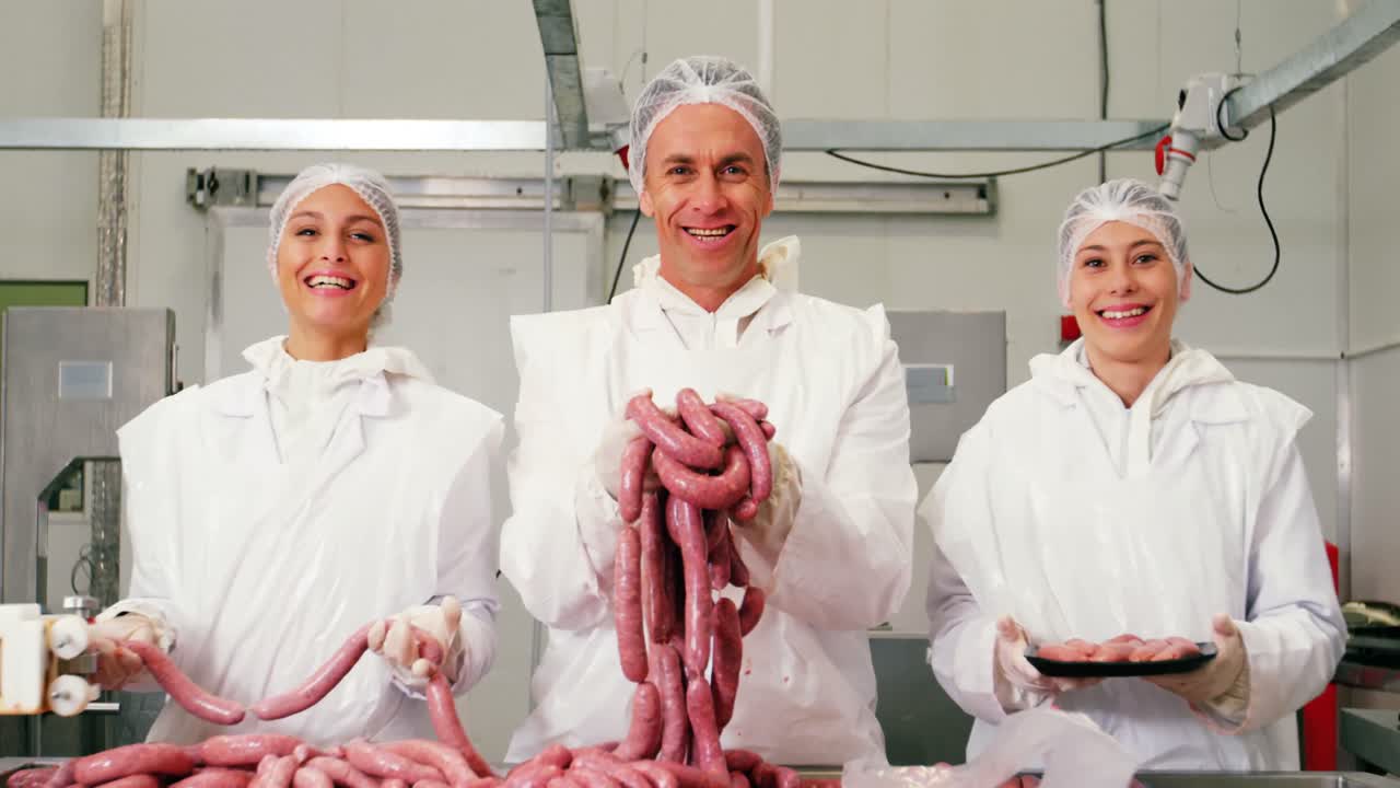 Team of butchers holding sausages