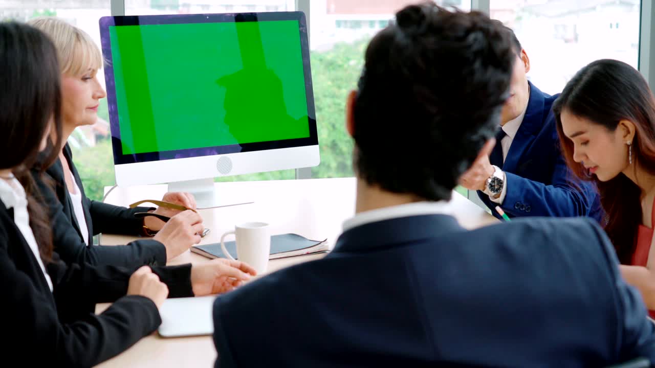 녹색 스크린을 가진 회의실에 있는 비즈니스 사람들