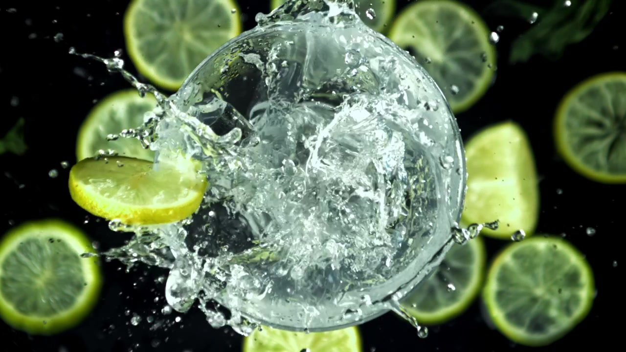 Ice Cubes Falling into a Glass of Water with Lemon Slice in Super Slow Motion