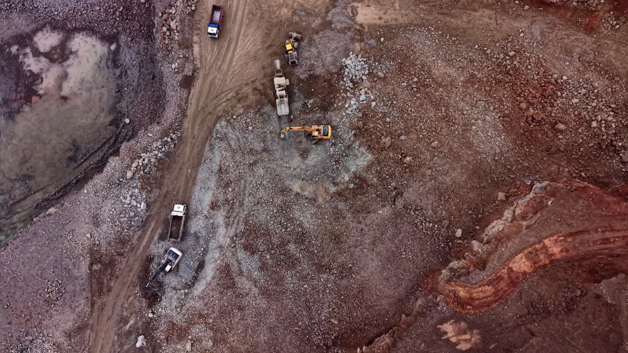 Heavy machinery working in a granite quarry during the day