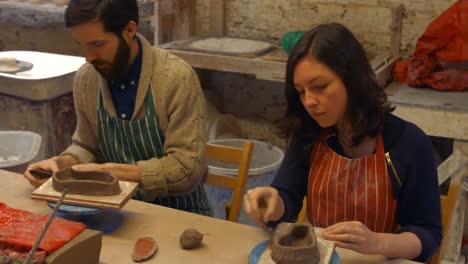 potter teaching his colleagues to mold the clay