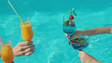 amigos disfrutando de cócteles en una piscina