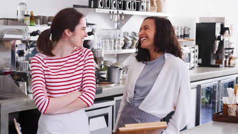 dos dueñas de cafeterías sonriendo detrás del mostrador