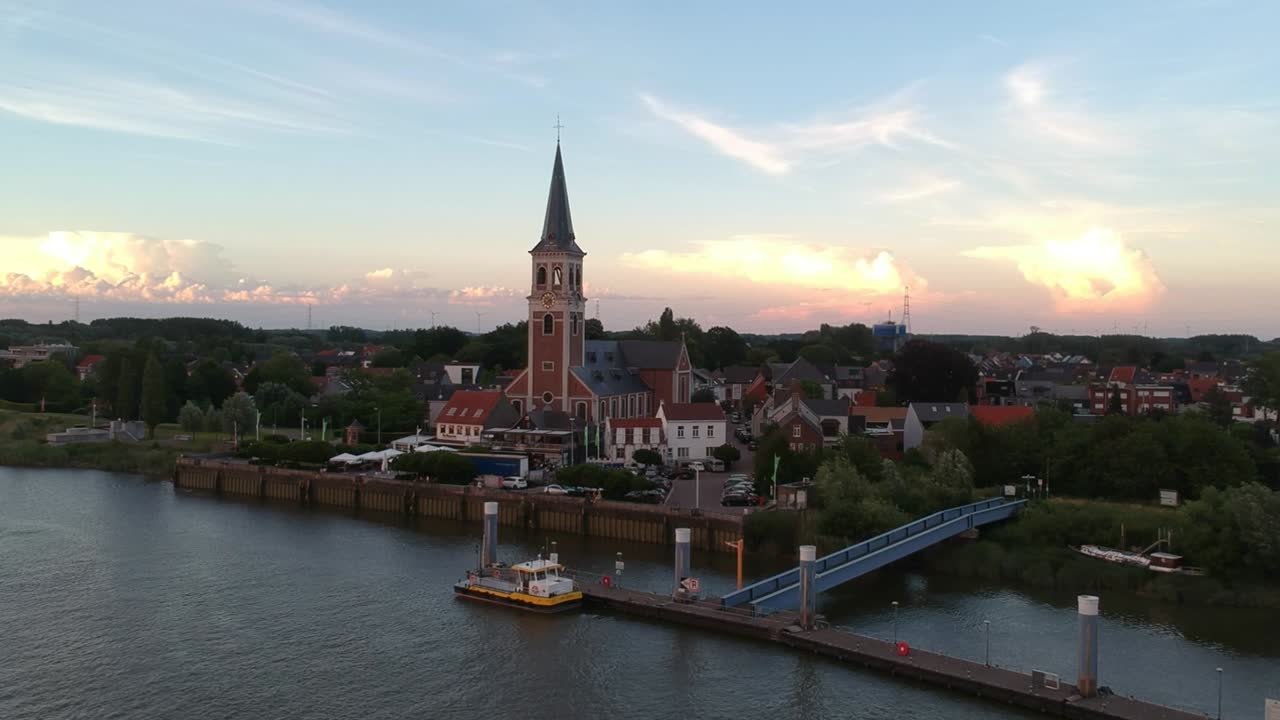 majestuosa torre de la iglesia y pequeño muelle al lado en bélgica, vista aérea