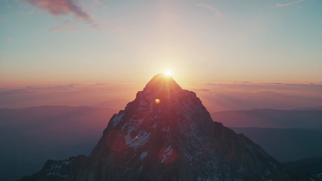 Rising sun behind jagged peak illuminating rock, snow at high alpine sunrise, creating lens flares