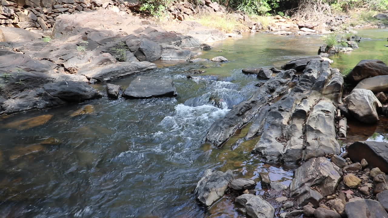 Plano estático de un lecho de río pedregoso en un día soleado