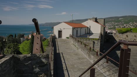 castle with italian flag on the roof and in the background the adriatic sea