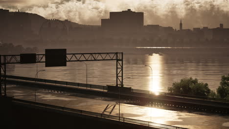 puesta de sol sobre un paisaje urbano con un puente y un río
