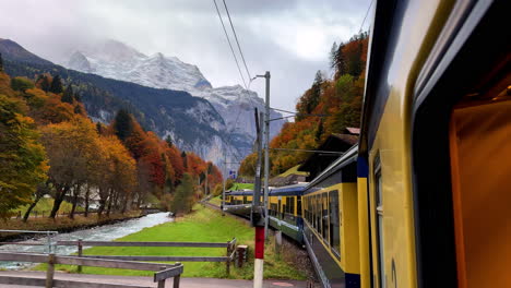 swiss alps train ride grindelwalk jungfrau interlaken to lauterbrunnen switzerland late october november autumn fall colors river late afternoon bernese overland thun bern region snow peak glacier