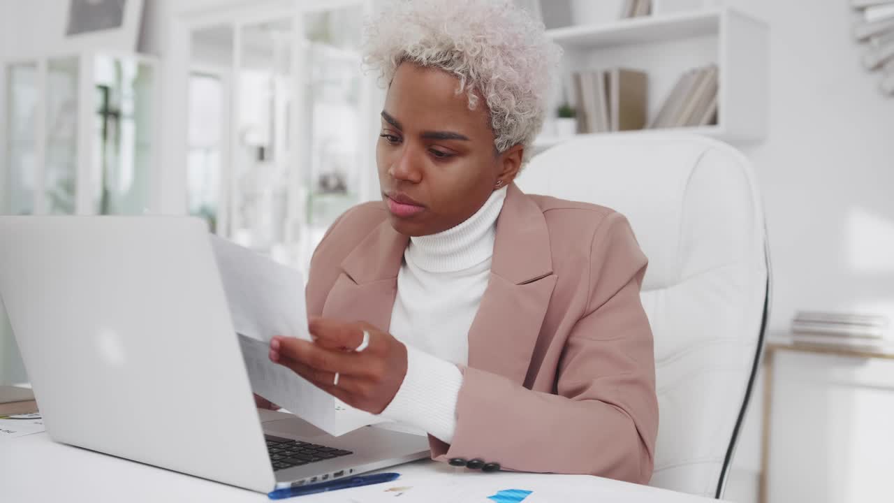 Puzzled young african american woman entrepreneur read letter frightened look