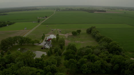 aerial over farmland with barn and farmhouse and horses