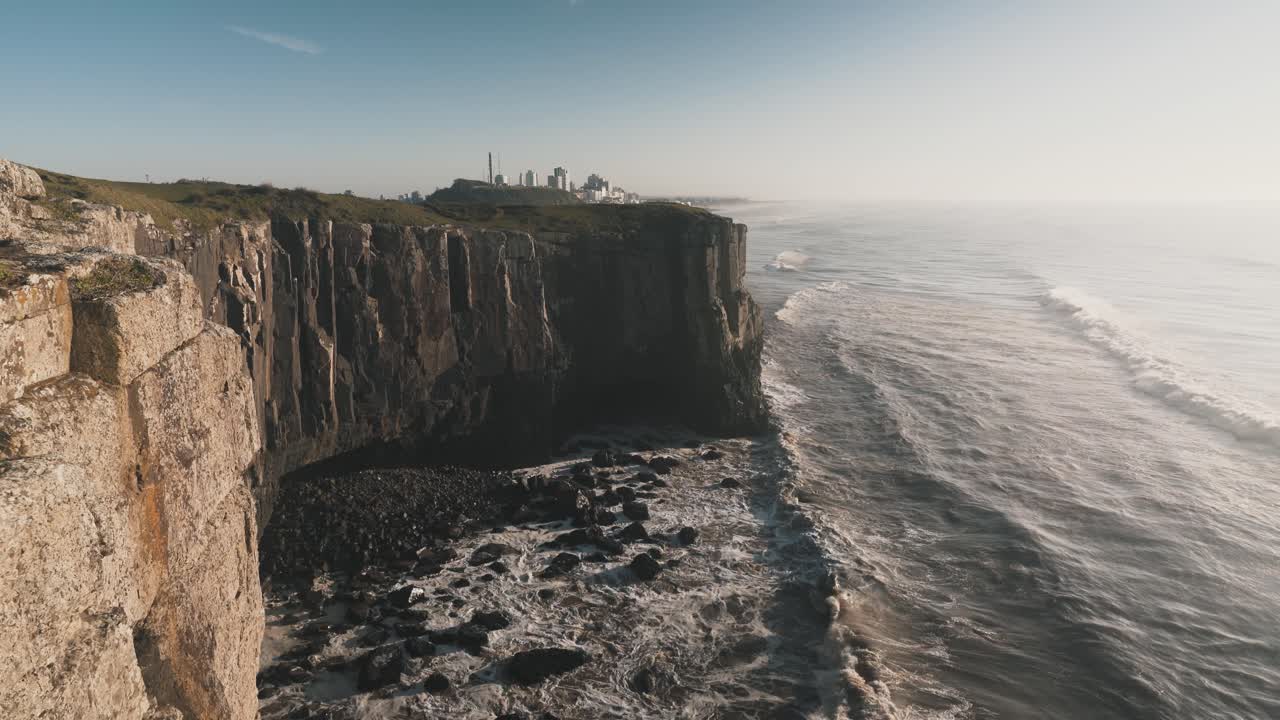 olas rompiendo en altos acantilados rocosos en el océano atlántico al amanecer