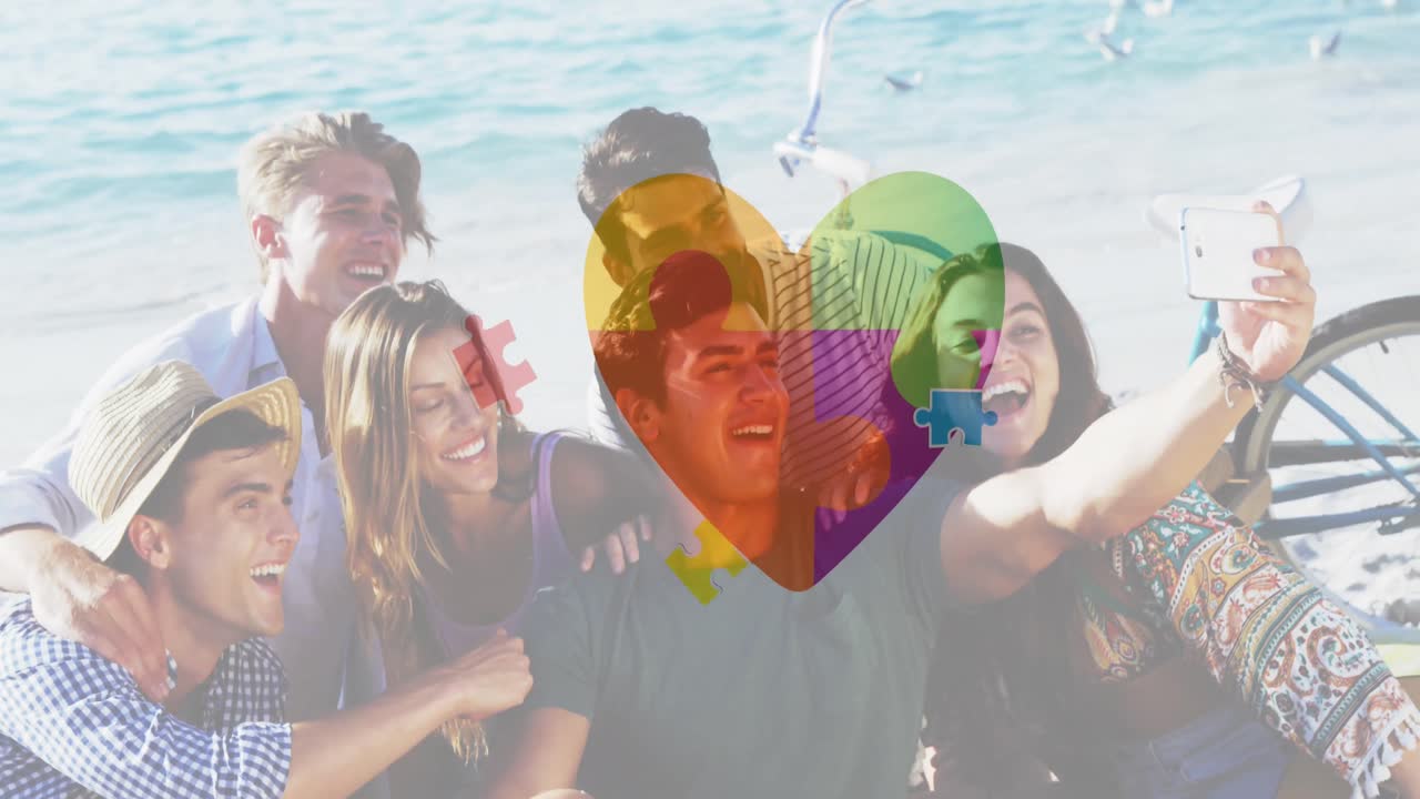 Animation of colourful puzzle pieces heart over happy friends at summer beach party