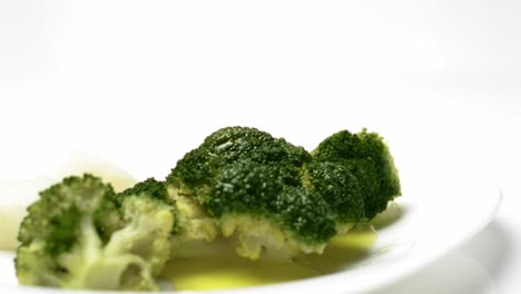Tasty-broccoli-with-olive-oil-plate-on-White-background,-dolly-in-shot