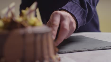 Close-Up-Shot-Of-Person-At-Home-Cutting-Slice-From-Chocolate-Celebration-Cake-On-Table-5