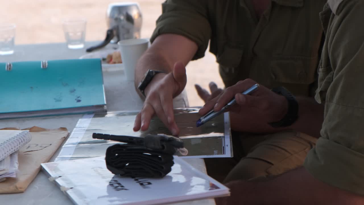close-up of army combat officer's hands plan their itinerary