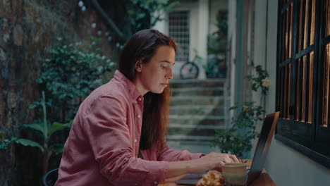 girl working on laptop and drinking tea in patio in the evening