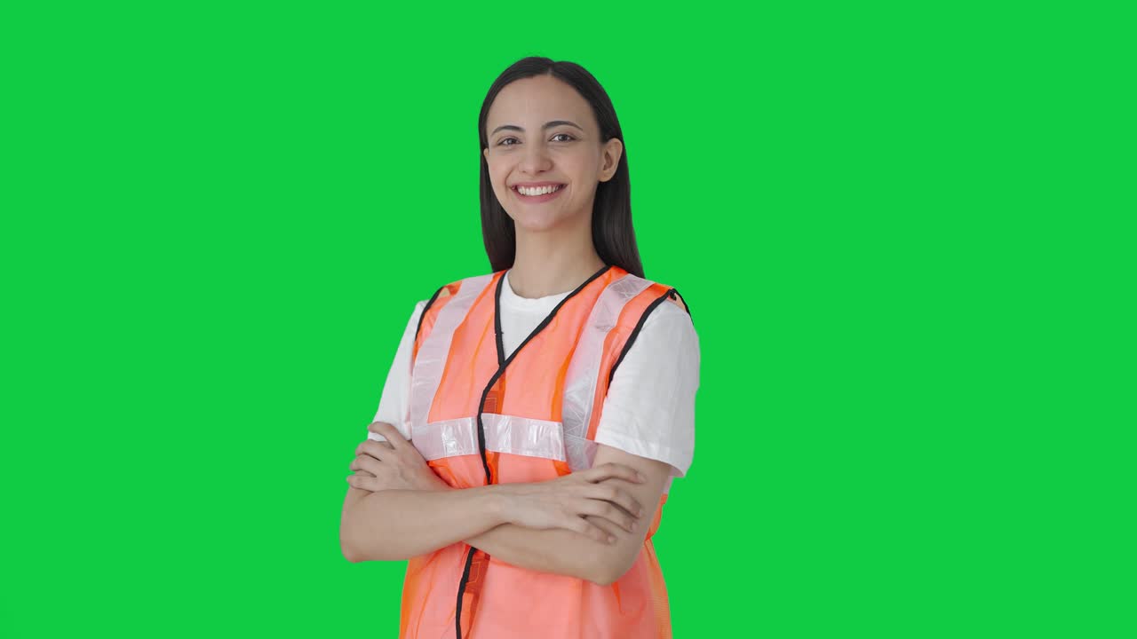 Membro feliz da equipe de solo do aeroporto indiano de braços cruzados com fundo verde.