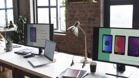 modern business workspace is equipped with a laptop, two monitors, and various office supplies