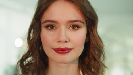 young brown-eyed woman with makeup smiles looking in camera