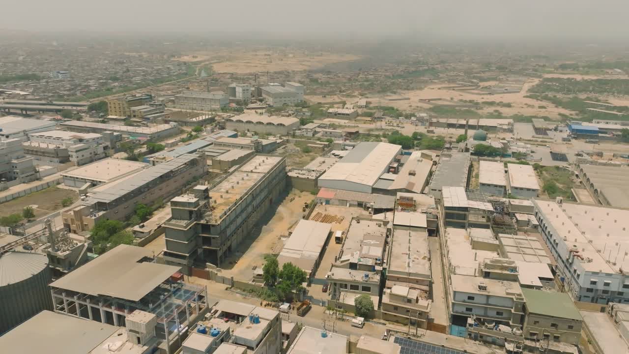 Aerial view of large silos and industrial buildings in karachi, pakistan, showcasing organized layout under clear skies