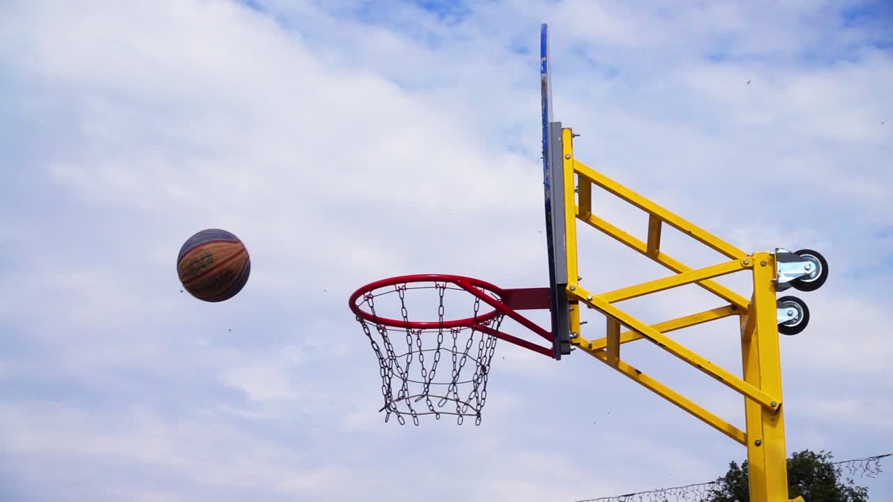 Pallacanestro da strada. La palla vola verso il canestro. Al rallentatore