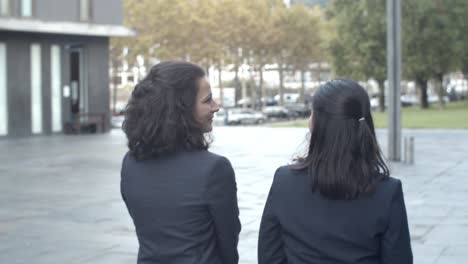 rear view of female coworkers going from work and talking