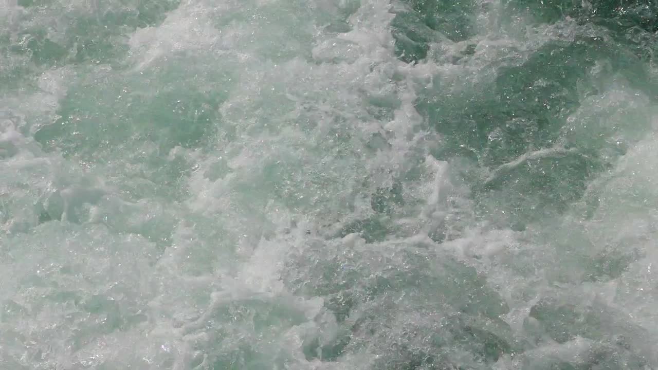 primer plano de la espuma de aguas blancas en un cuerpo de agua