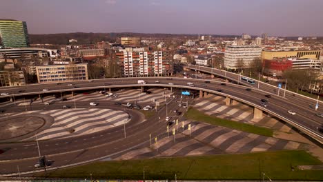 Aerial-approach-of-large-overpass-intersection-crossroad-with-traffic-passing-by-on-highway-intersection-in-urban-surrounding