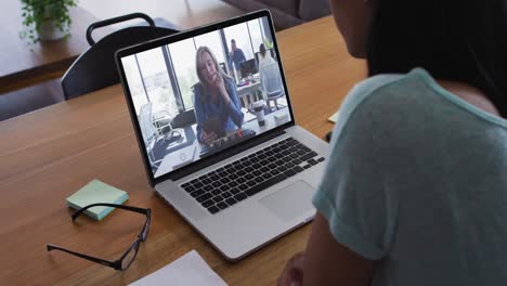 Mid-section-of-african-american-woman-having-a-video-call-with-female-colleague-on-laptop