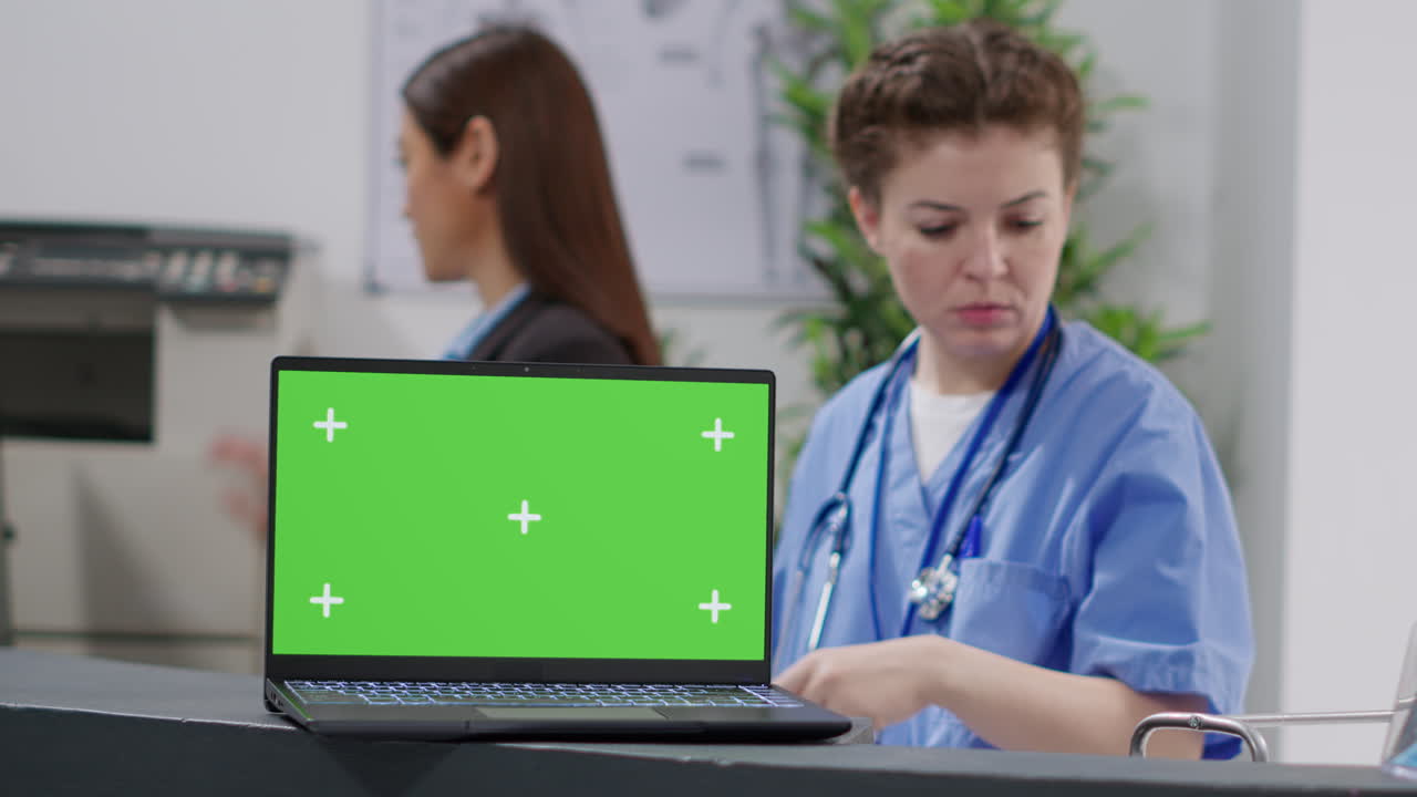Medical Staff at Reception with Green Screen Laptop