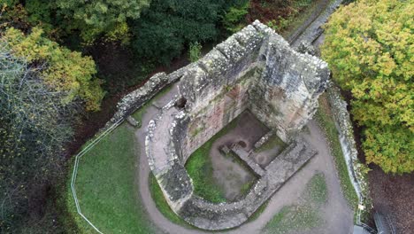 vista aérea sobre el castillo de ewloe ruinas abandonadas escondidas en el bosque otoñal ojo de pájaro órbita derecha