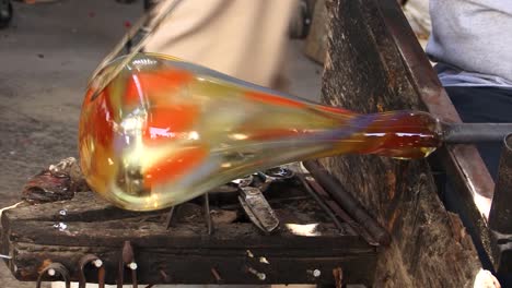 detail of how a blown glass vase is shaped by a craftsman