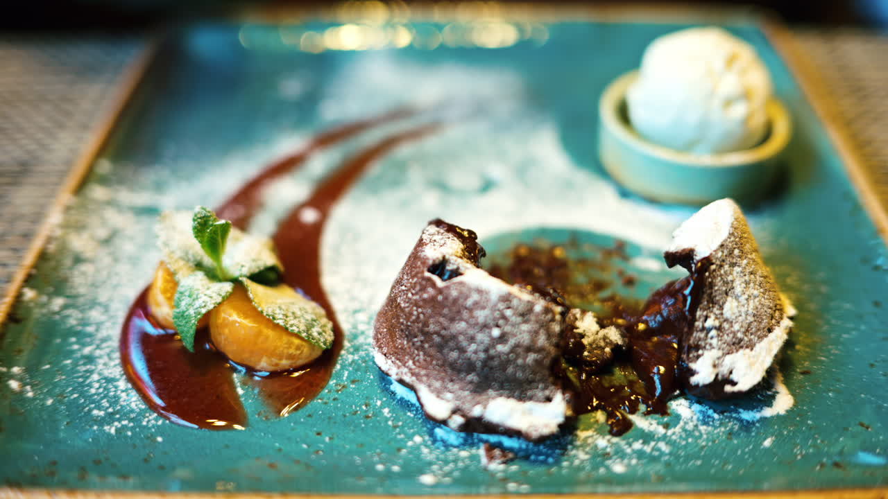 Chocolate lava cake with ice cream and orange decoration in a restaurant