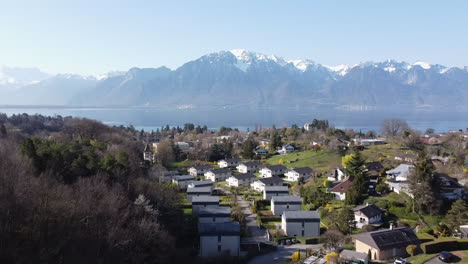 aerial fly over above montreaux, switzerland on a sunny day with the alps in the background